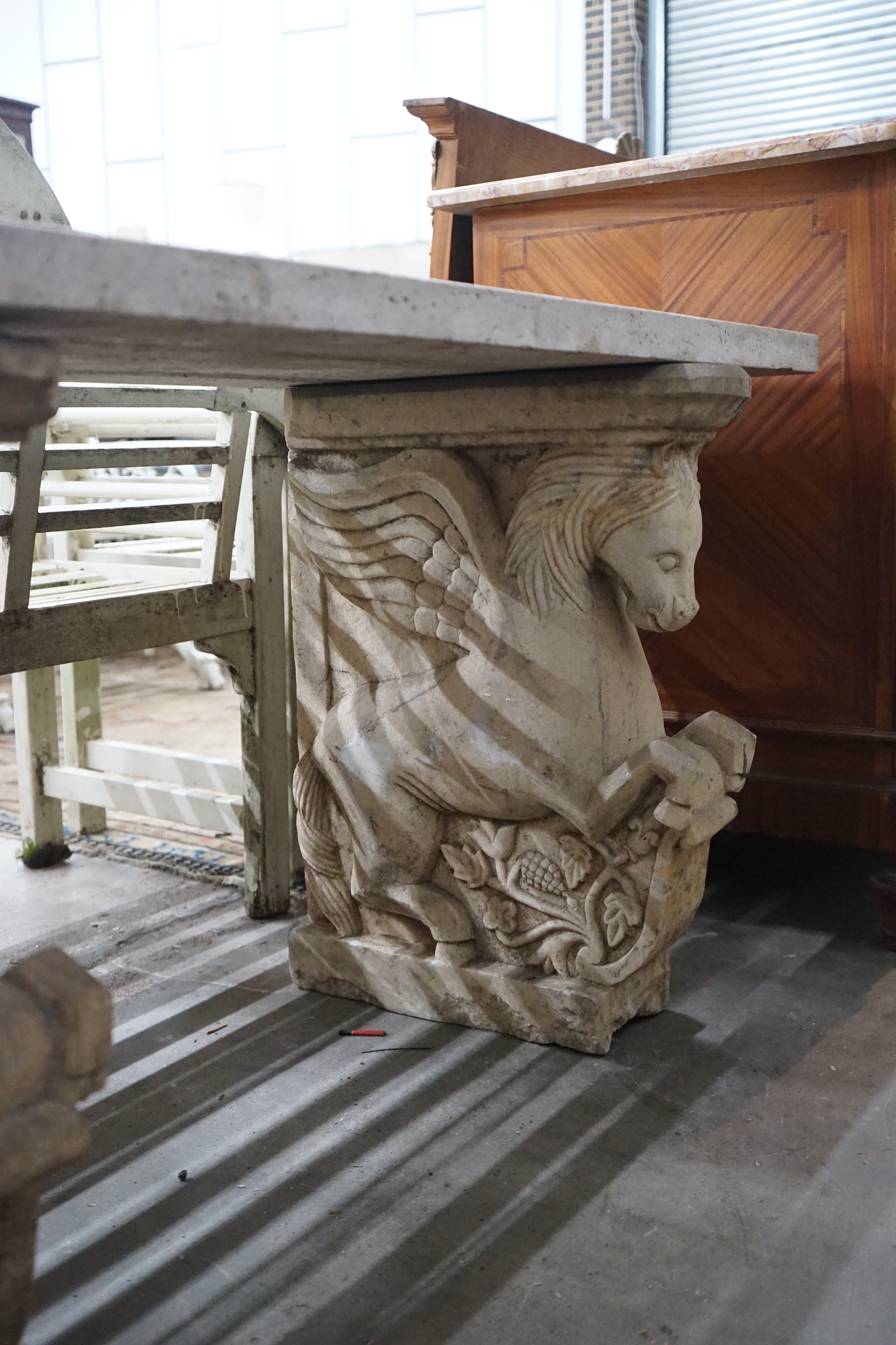 A carved stone Pegasus console table, width 127cm, depth 46cm, height 66cm